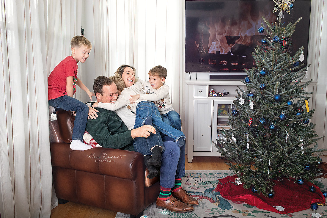 Parents and kids snuggling during an in-home lifestyle holiday family photography session with Alina Renert, Wheeling, IL. 