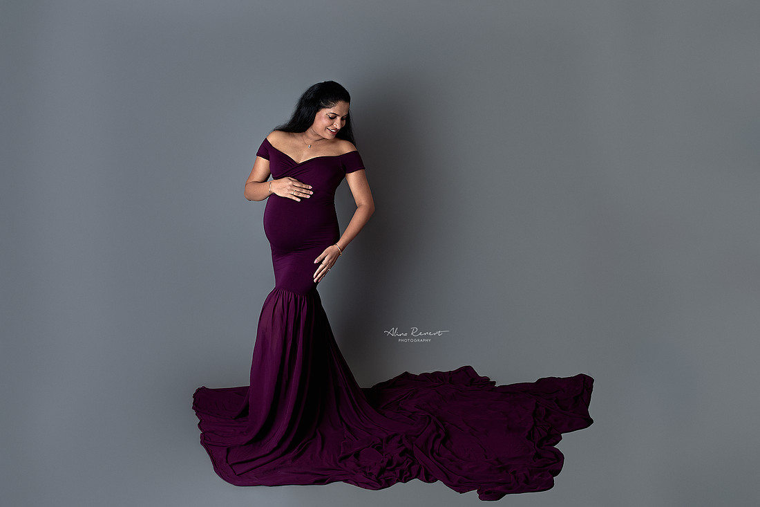 Sultry and sexy maternity portraits in a Northwest Chicago suburbs studio with a fitted, flowing gown and a neutral backdrop.
