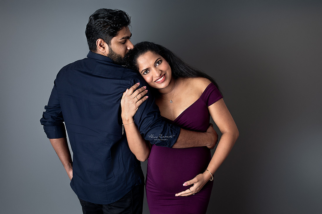 Maternity couples portraits in a Northwest Chicago suburbs studio with a fitted gown and a neutral backdrop.