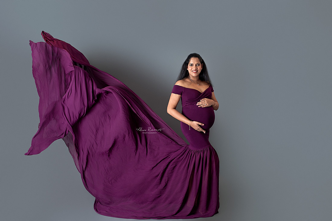 Maternity portraits in a Northwest Chicago suburbs studio with a fitted flying gown and a neutral backdrop.