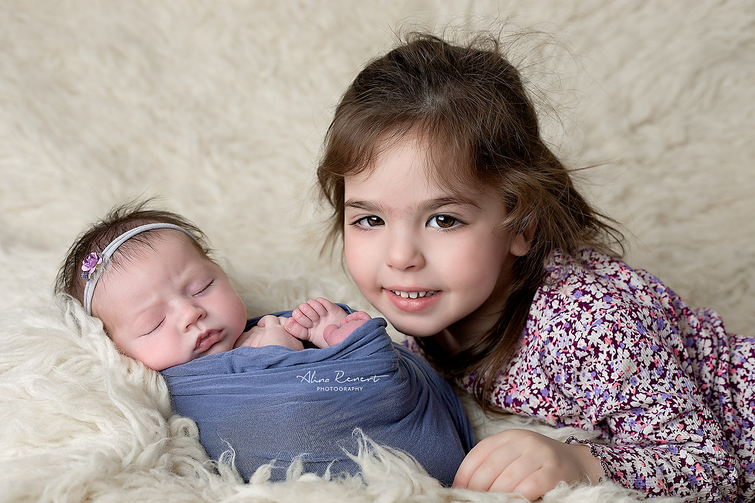 Sibling newborn photography, Wheeling, IL, featuring big sister Alina and newborn baby Daniella on cream fur.